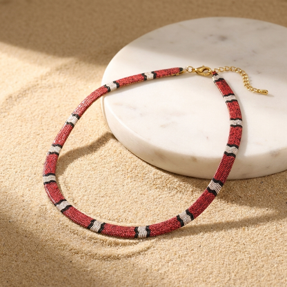 Collana a serpente Serpia in Rosso Corallo su pietra bianca e sabbia